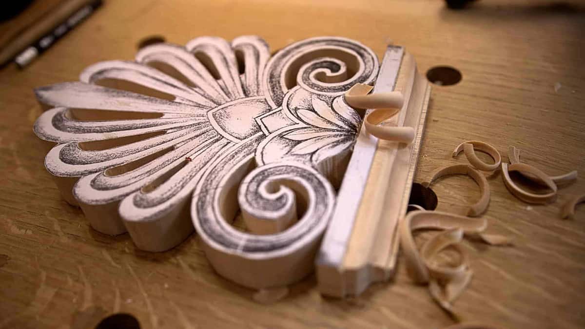 Charcoal shading survives on a roughed palmette, right next to a strip of molding and a pile of curled shavings