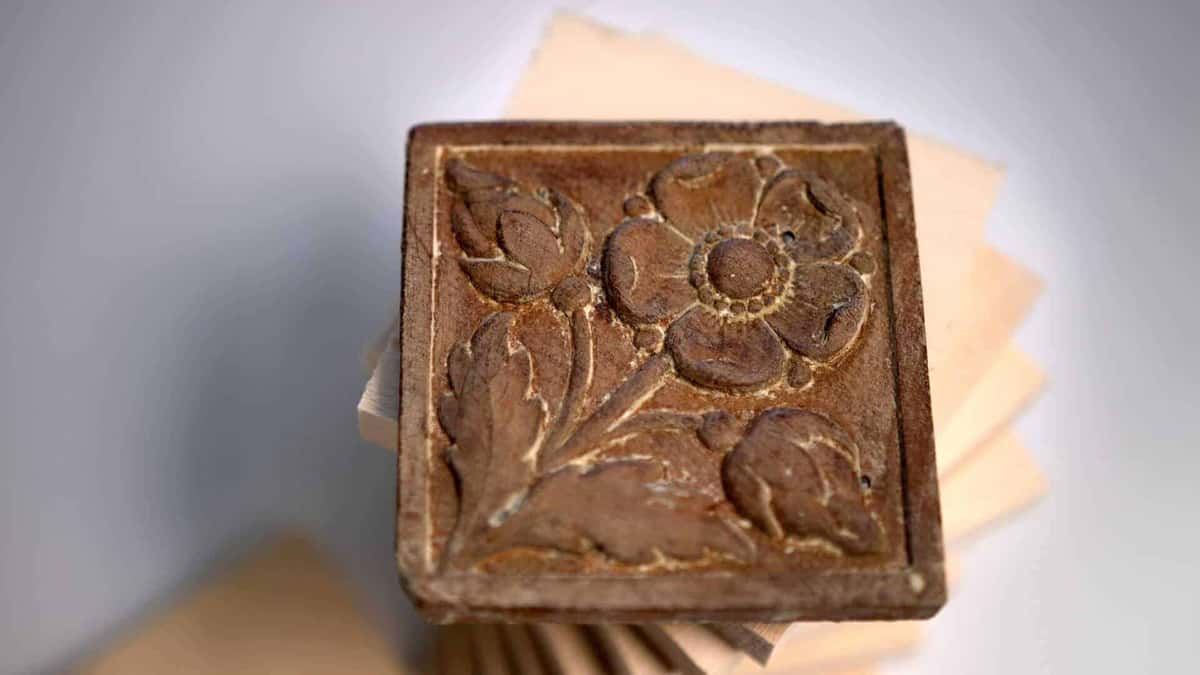 Worn antique tile, dark and softened at every edge, set on pale uncarved blanks
