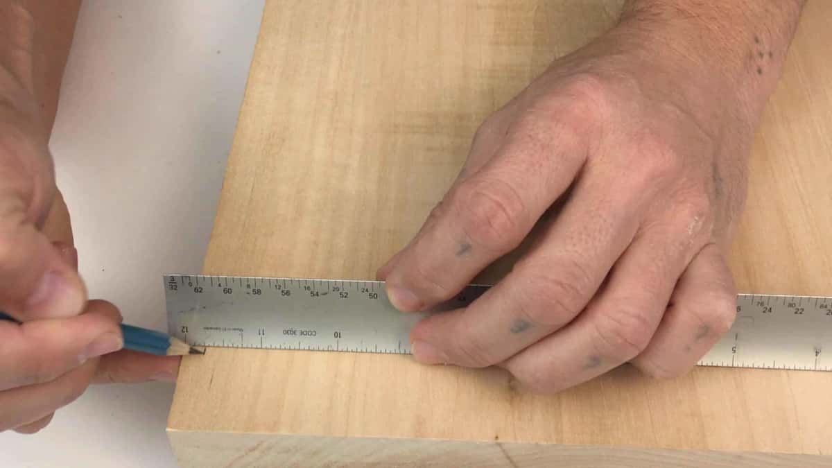 Steel rule and a pencil laying out the border margin before any relief carving starts here