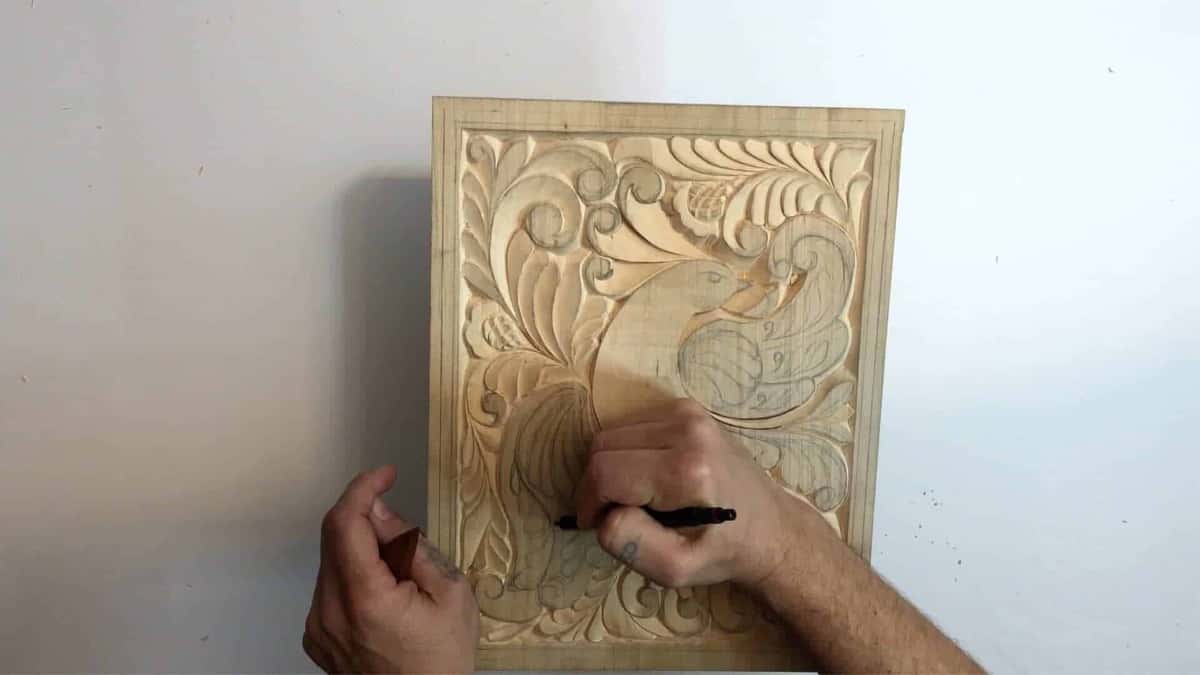 Marker in the right hand over the bird panel, a small tool held in the left