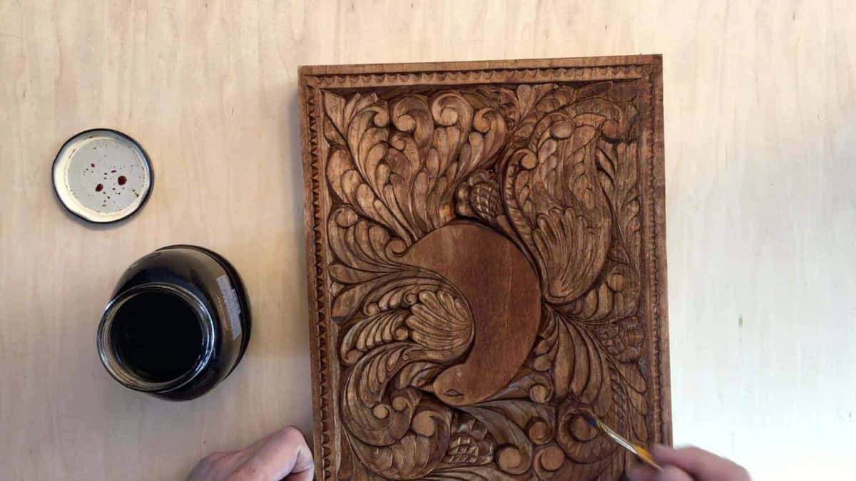 Same bird panel after the dark finish, open can and brush beside