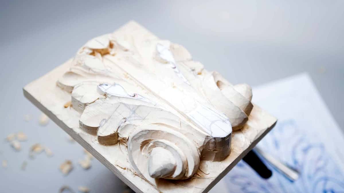 Paper pattern still glued to a roughed scroll block, chips lying where they fell