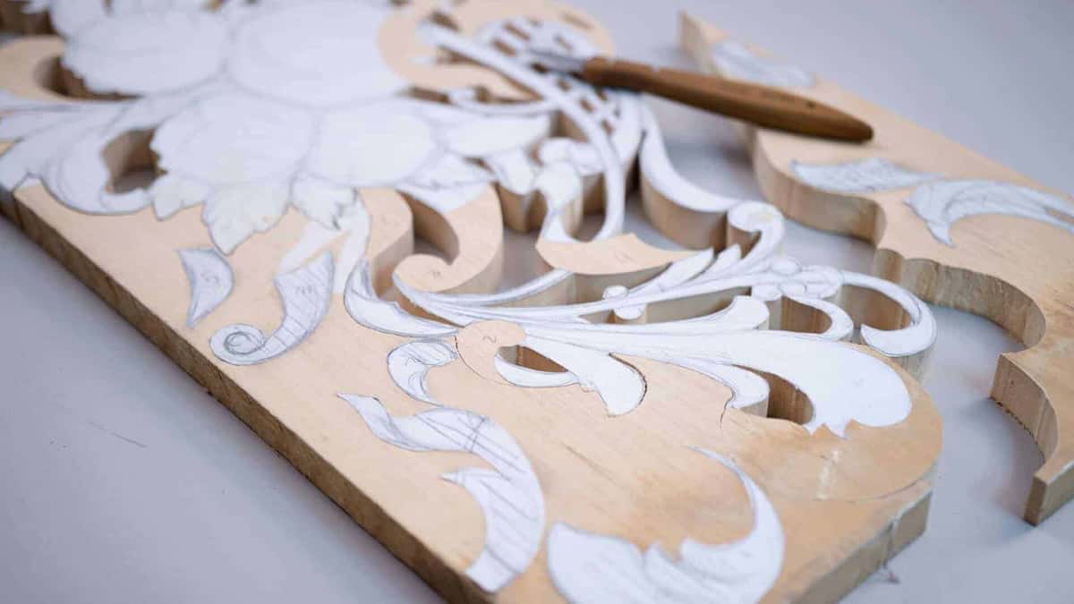 A blank part carved and part drawn, one gouge lying across it where somebody put it down