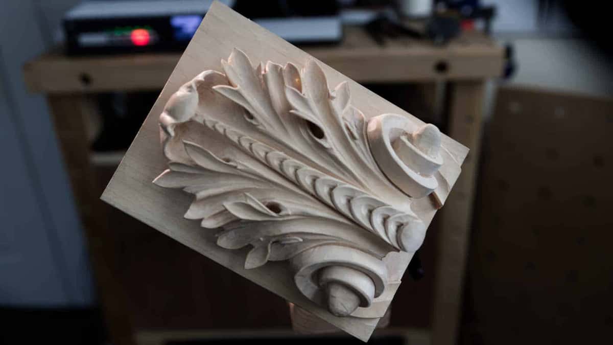 Completed acanthus panel tilted toward the camera, still bare wood.