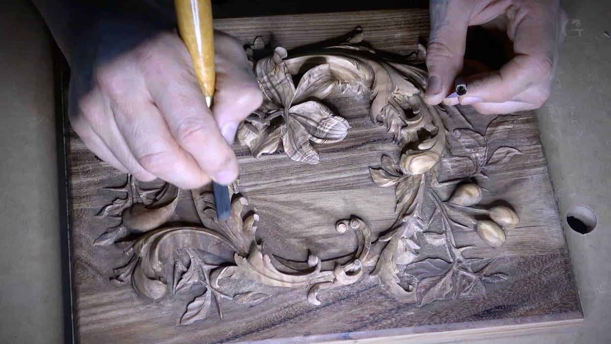 One gouge, one punch, both hands on a carved lily panel