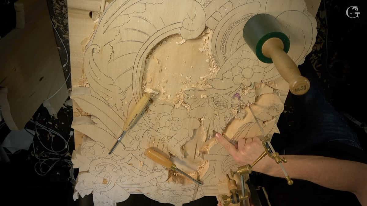Large Venetian panel part carved, two gouges lying on it and a mallet alongside