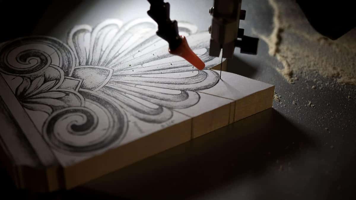 Shell and scroll design drawn in pencil on a board waiting at the bandsaw