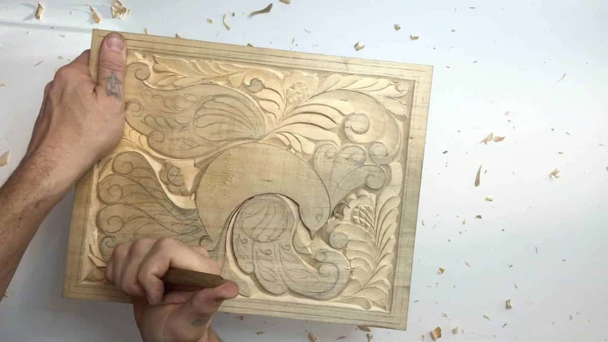 Fingers pin the far corner while the other hand works a tool along the border
