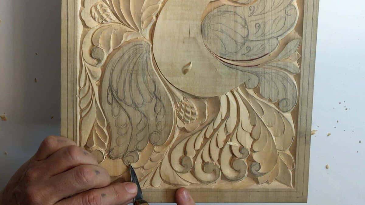 Knife cutting a wing feather while pencil layout lines still show in the ground