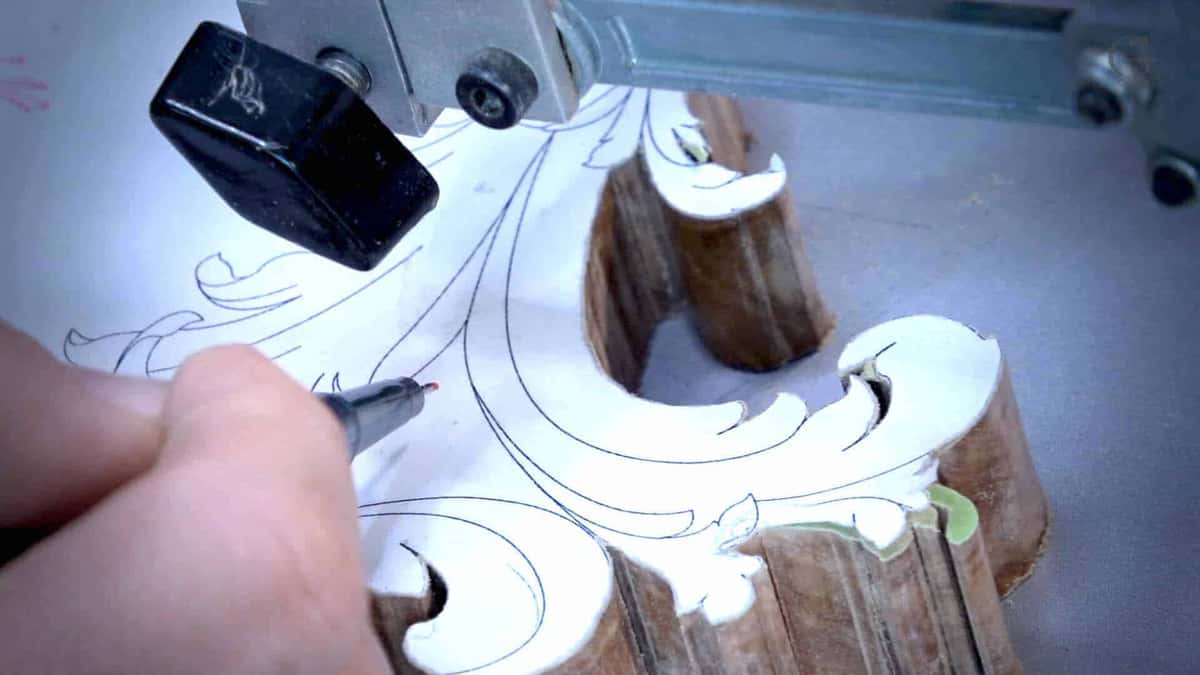 Paper pattern glued onto olive wood, and the saw removes the inside waste