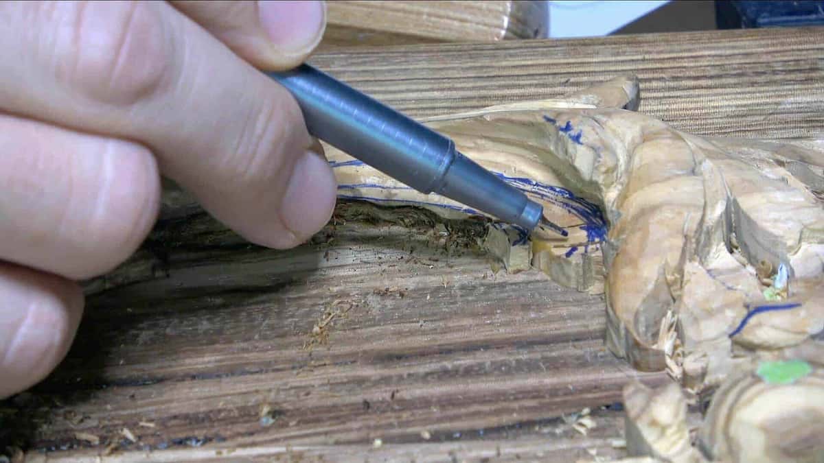 Gouge pressed into figured olive wood panel
