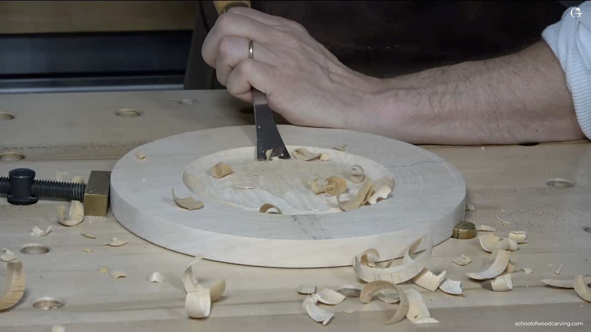 Shavings curling off a soft round panel worked with hand pressure and no mallet