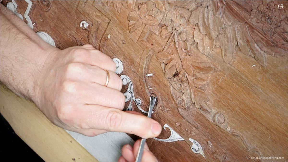A small tool working the surface of a dark walnut panel where every pass fights dense fiber