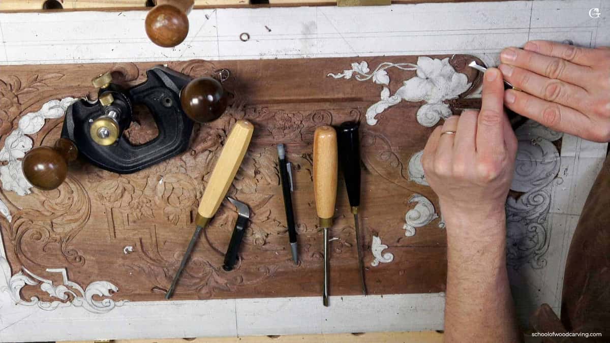 Hand plane and gouges beside a panel
