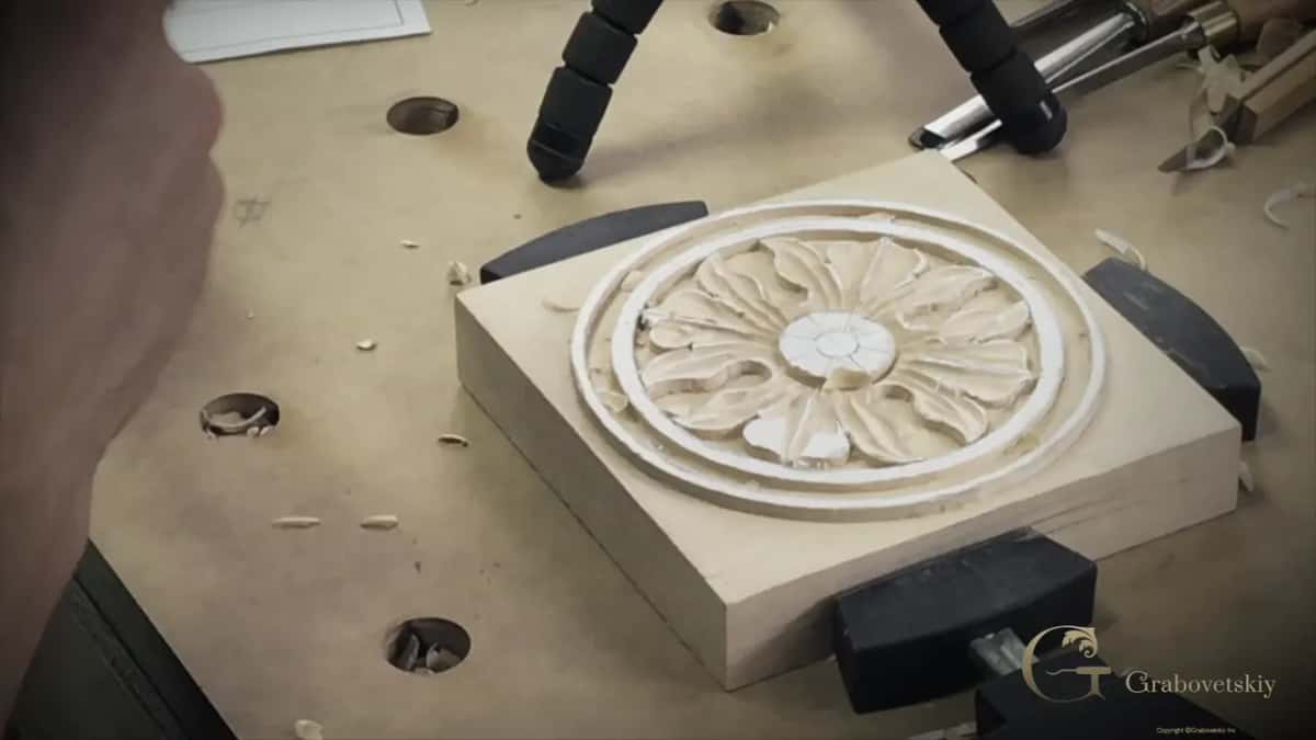 The bench itself: dog holes, chips, rubber clamp pads and a finished rosette sitting square on its blank.