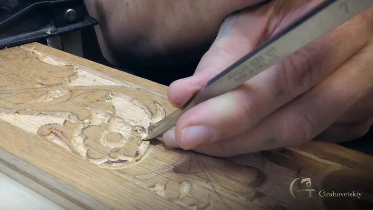Petal by petal, a small pointed tool cleans a carved rosette, and the grain shows through every petal.