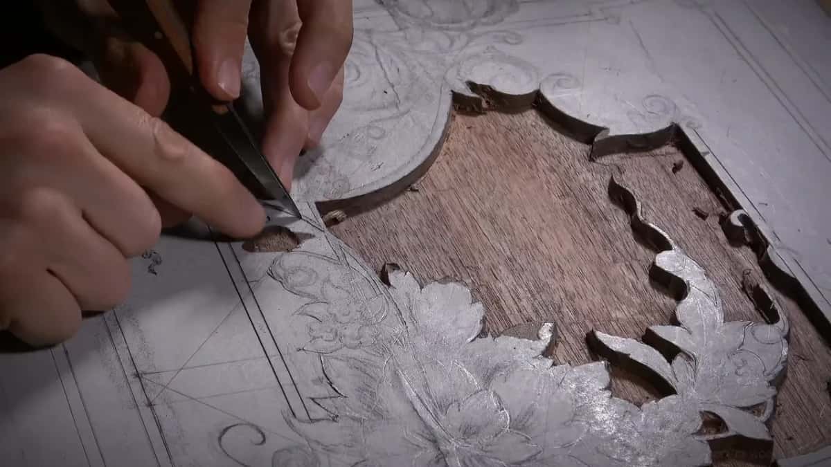 Where the white coated surface has been carved away, plain brown wood shows in the sunken ground of the panel.