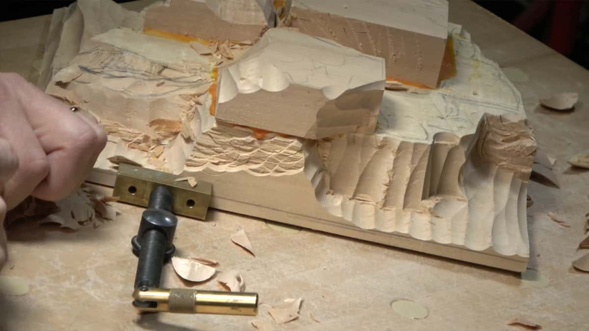 A relief carving held down by a brass clamp
