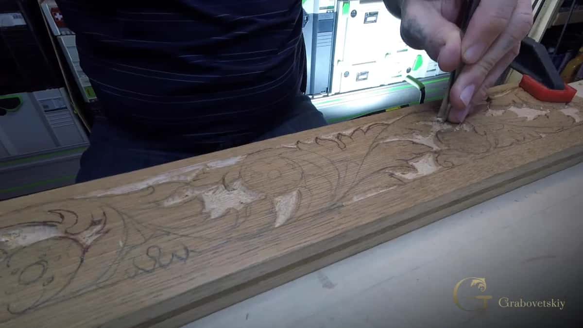 A long oak molding clamped down with an acanthus scroll drawn on it and partly carved, one hand at the line