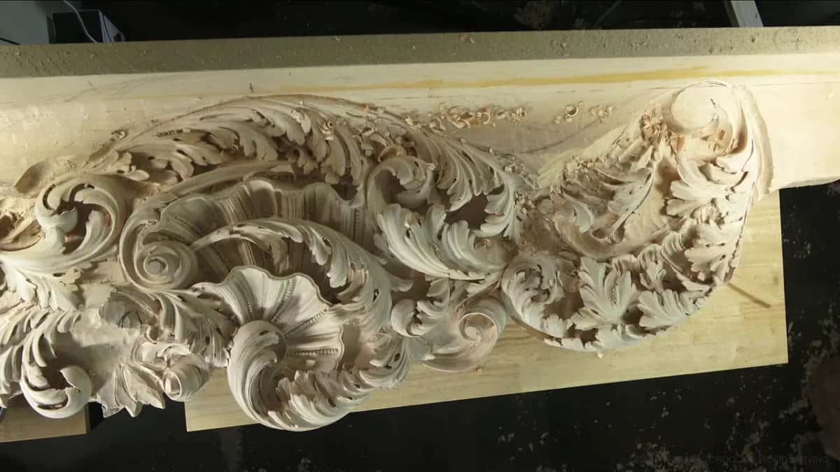 Curling leaves and shells run the length of a pale frieze, throwing deep shadow across the bench.