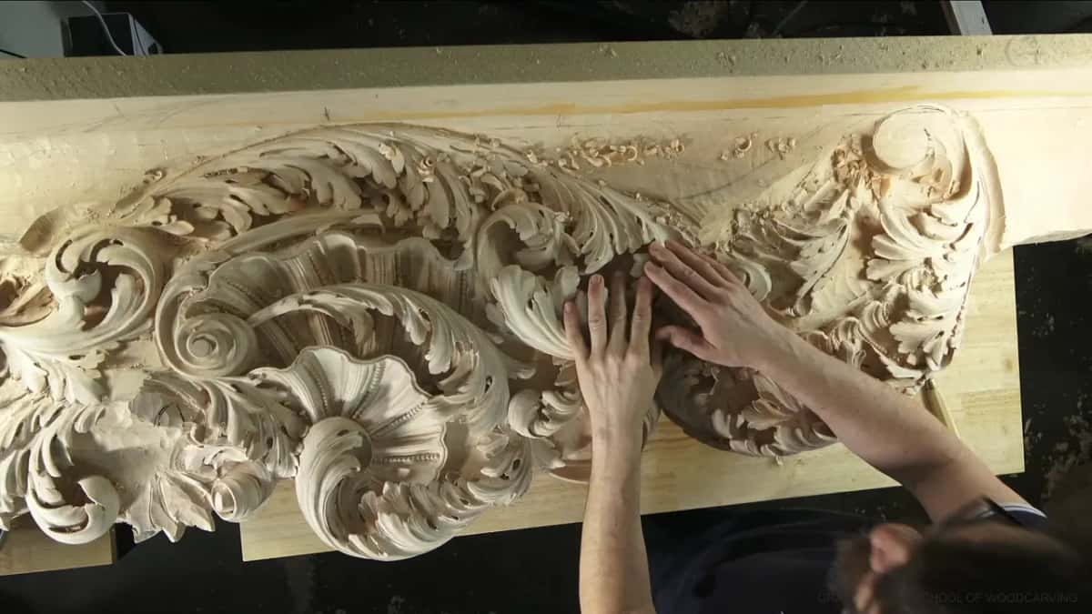 Fingers travel over the ridges of the frieze, reading the surface instead of looking at it.