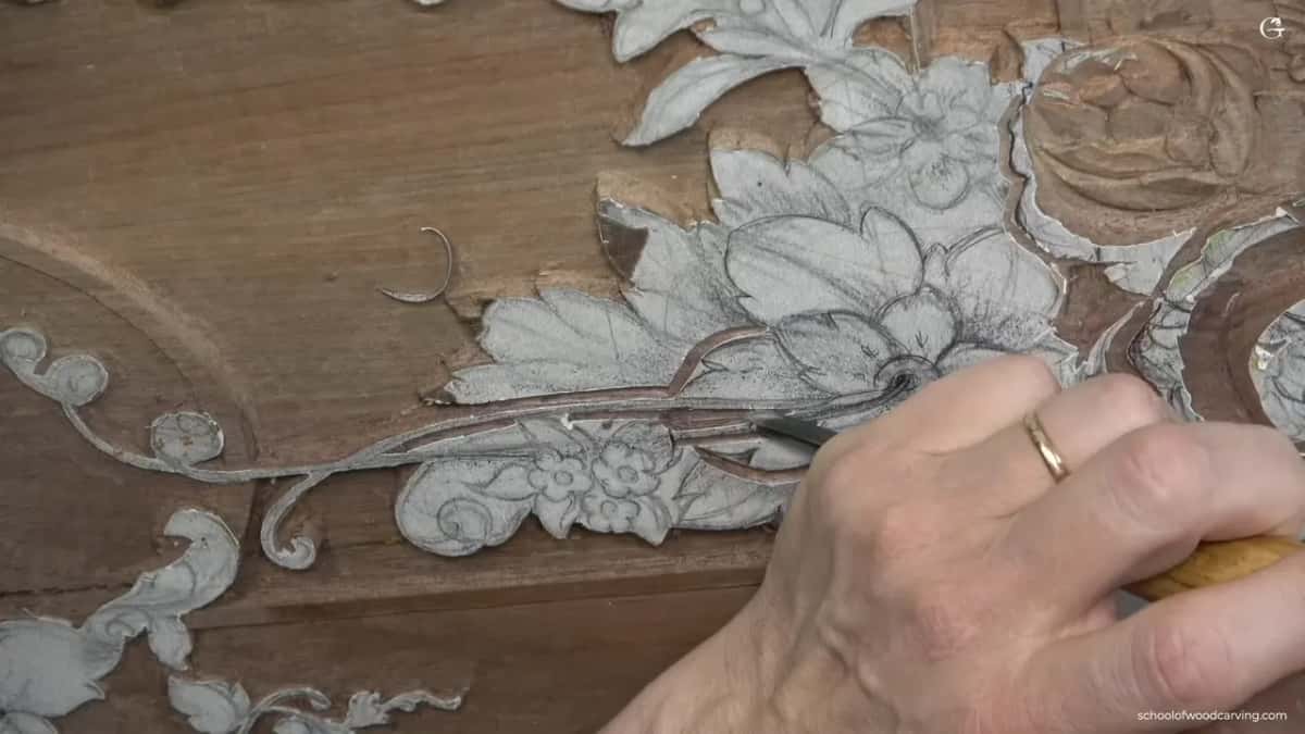 Following a drawn stem, a gouge carves the outline through glued paper into the brown panel.