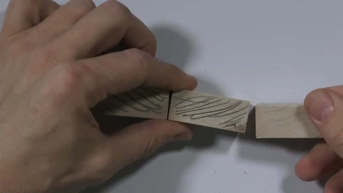 Matching grain lines connect two wood blocks positioned edge to edge for a joint.