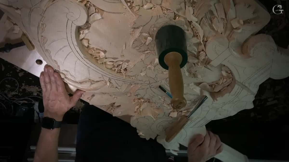 Overhead of a broad panel covered in pencil layout, a mallet standing on end and a rule near the lower edge.