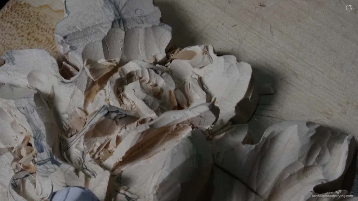 A grape onlay roughed out only, fibres still torn and layout lines showing under the loose chips.
