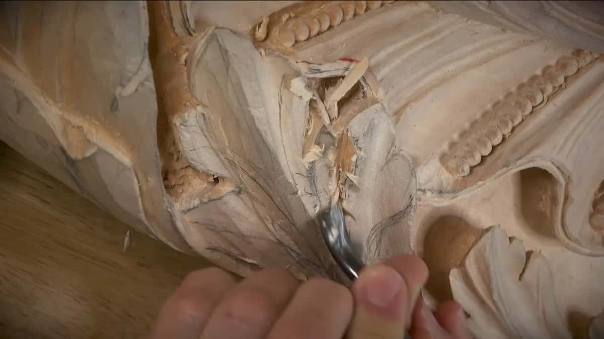 A ragged torn patch stands up in the middle of a carved leaf, right where the gouge is working.