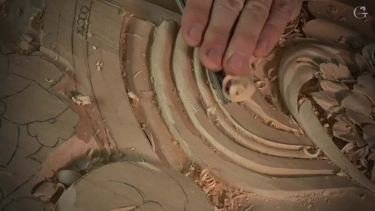 A single curl lifting off the band just ahead of the edge, fingertips resting on the steel above