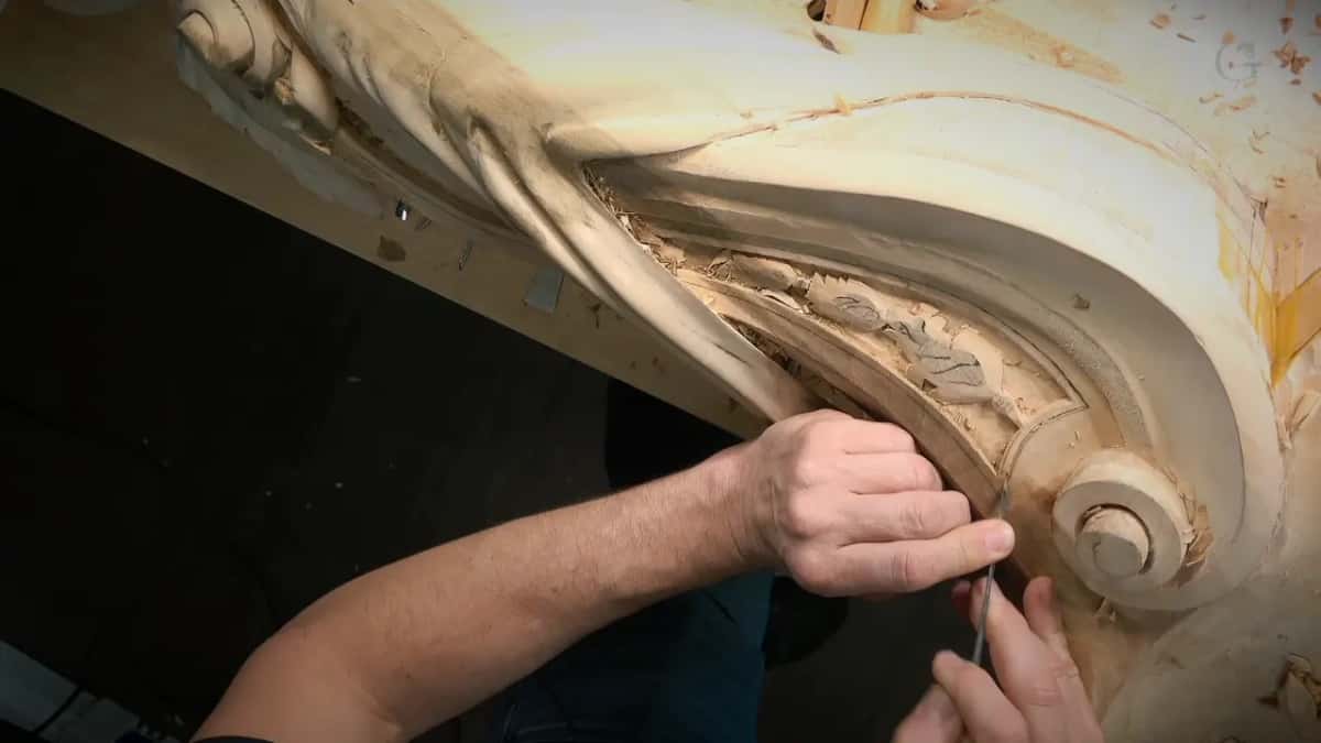 Both hands push a small tool into the border, seen from overhead