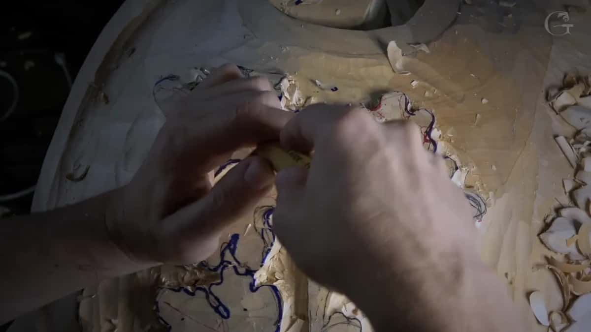 Knuckles close over a short tool as it slips between two lobes drawn in blue and red