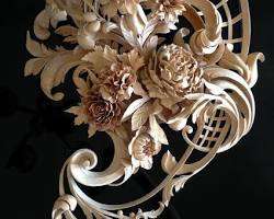 Alt Text: A beautifully detailed wood carving featuring elegant flowers and intricate leaf designs, showcasing the artistry involved in wood carving classes and lessons.