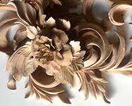 A detailed and intricate wood carving design featuring flowers and swirling patterns. This artwork showcases the beauty and skill involved in wood carving, perfect for those interested in wood carving classes and lessons.