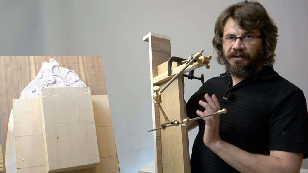 Alexander Grabovetskiy shows how a pointing machine rides over a carving on his bench