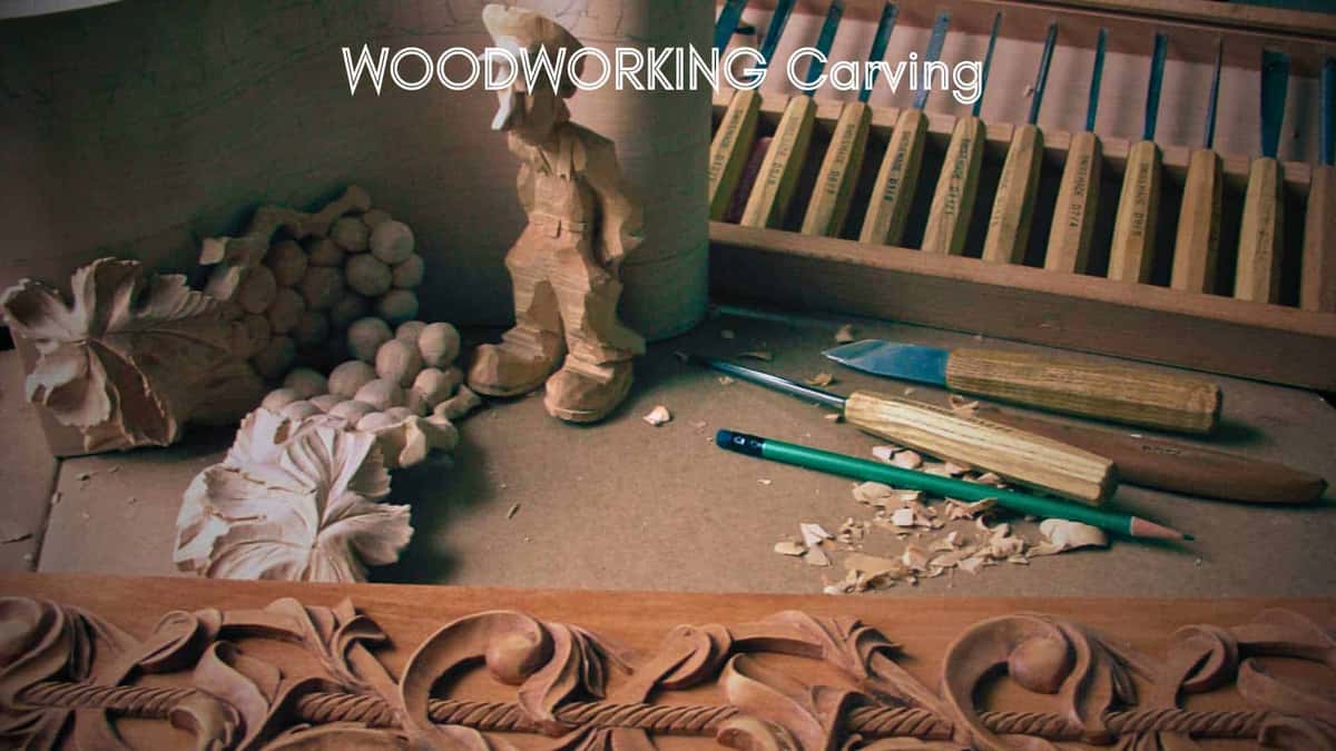 Workshop bench with pale basswood grape carvings beside a gouge rack