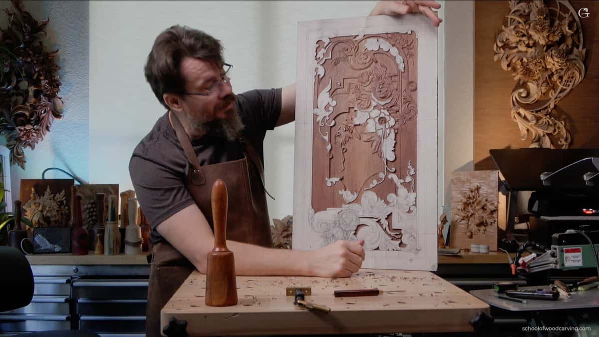 A man carving a piece of wood on a bench.