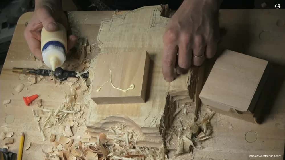 One bead, spread thin A bead of yellow glue laid in an S across one plain block, a second waiting at the right