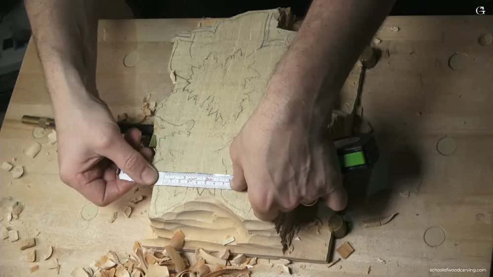 Measured twice on the wood A steel rule and pencil marking a roughed panel, the paper pattern still glued down