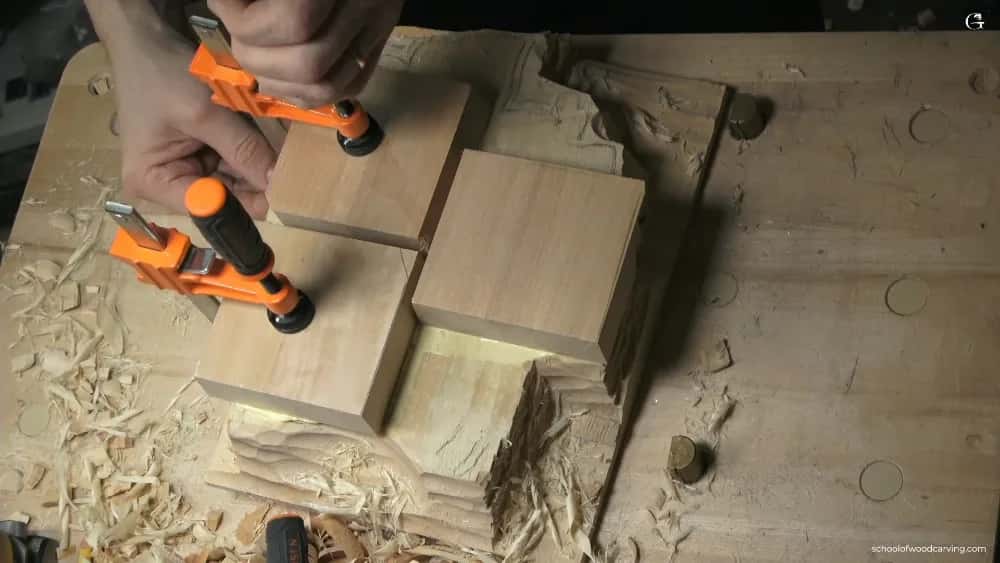 Even pressure, not hard Two orange clamps pulling a pair of pale blocks together