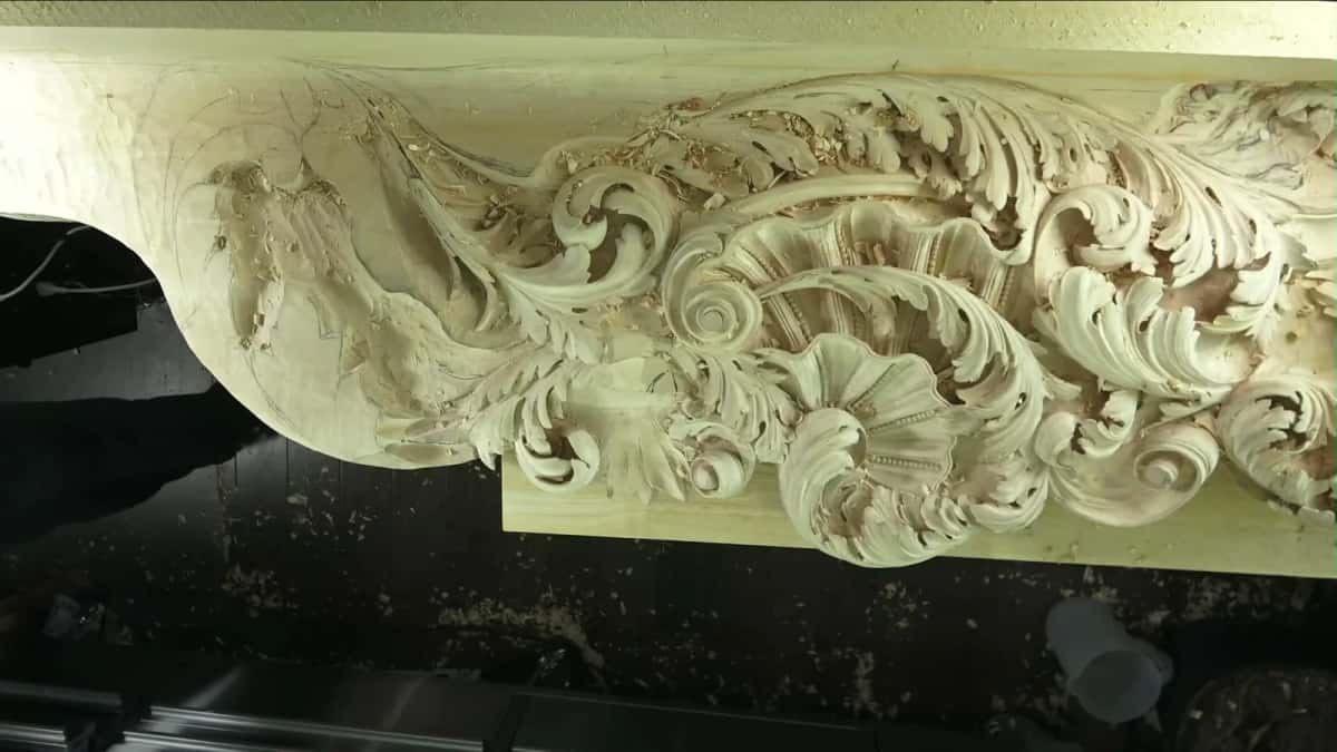 Wide, deep and still true A wide basswood panel carved with a Baroque acanthus and shell frieze, seen from above the bench it rests on