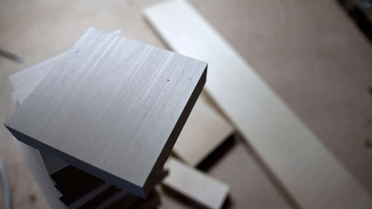 One squared basswood blank, with rough stock stacked behind it