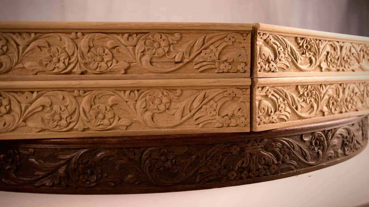Newly carved apron sections stacked above the dark original they copy