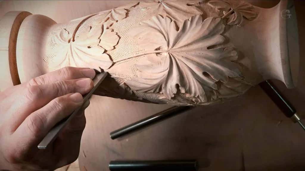 Two hands close over a carved leaf
