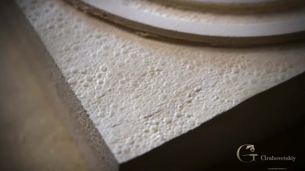 Raking light across a punched ground, hundreds of small round dents in flat basswood