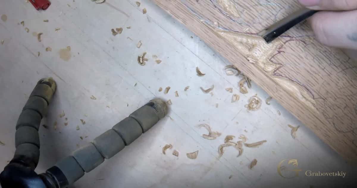 Chips and the gouge that made them Chips scattered right across a pale board with the gouge that made them lying where it was set down