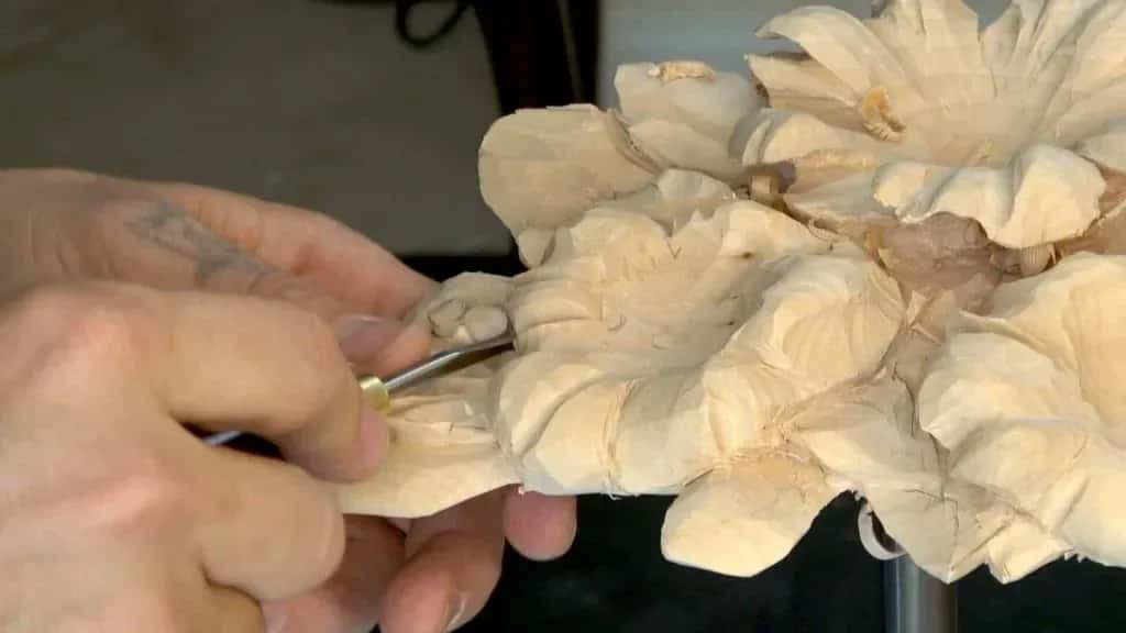 A small gouge running downhill with the grain around a carved flower