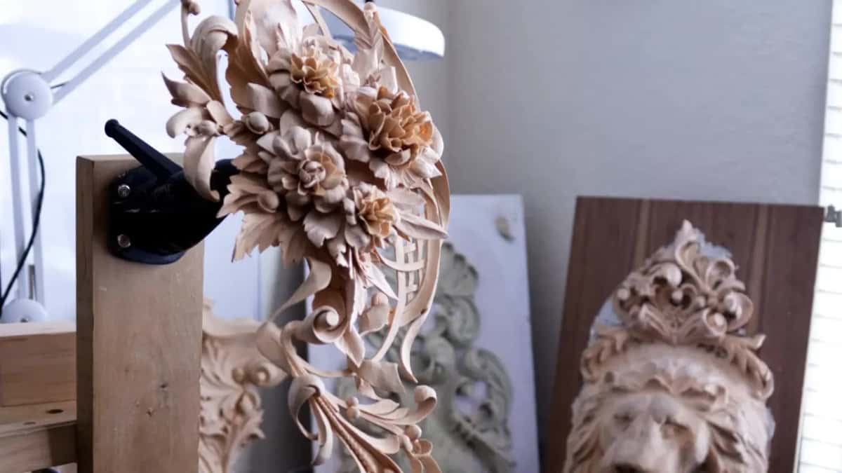 Deeply undercut roses and leaves stand clear of a pierced panel, with a lion head carving behind on the bench