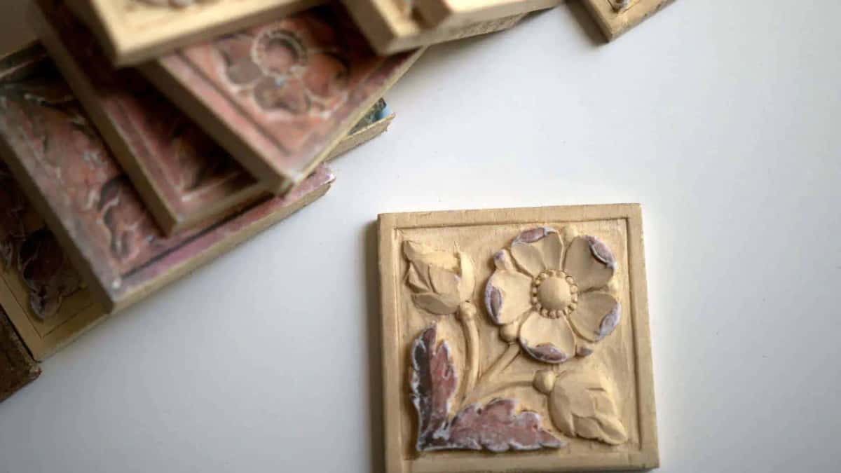 Fresh basswood flower tile in the foreground with worn painted originals stacked behind it